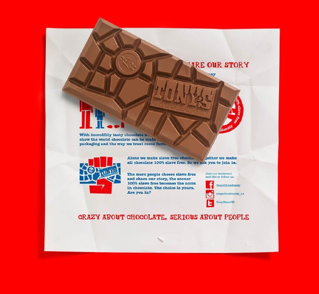 An unwrapped Tony's Chocolonely bar. The bar is on top of the inside of the flattened wrapper. The wrapper has details about how Tony's are aiming to make all chocolate slave-free.