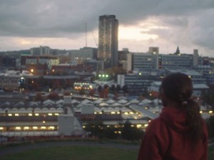 A woman looking over a view of Sheffield city centre at dawn
