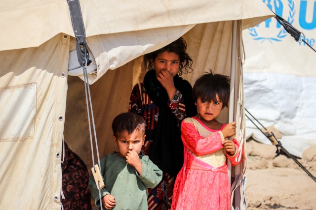 Three child refugees in a tent Kabul